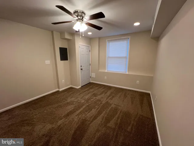 en empty room with windows and ceiling fan