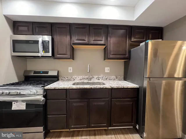 a kitchen with stainless steel appliances granite countertop a refrigerator stove and microwave
