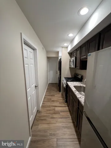 a kitchen with granite countertop a refrigerator and a sink