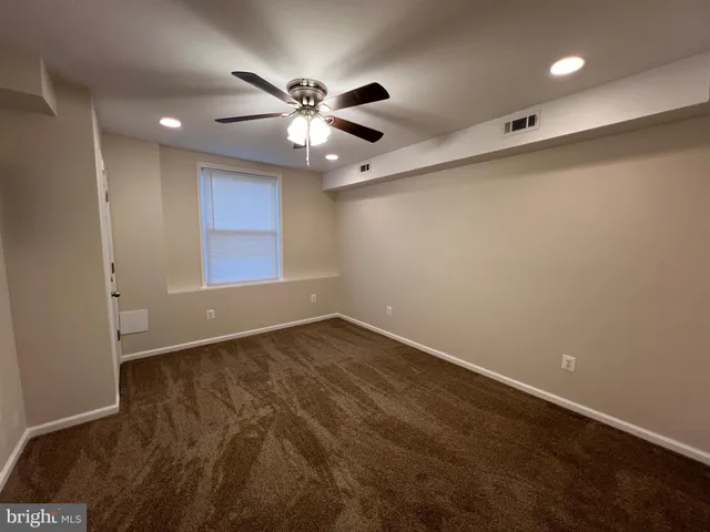 an empty room with windows and fan