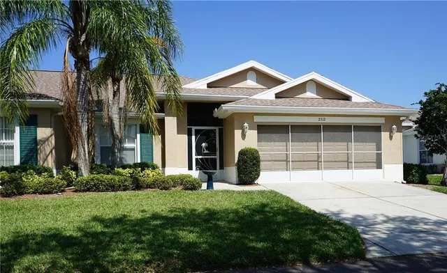 a front view of a house with a yard and potted plants