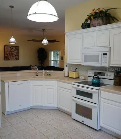 a kitchen with white cabinets and white appliances