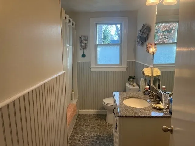 a bathroom with a sink vanity granite and toilet
