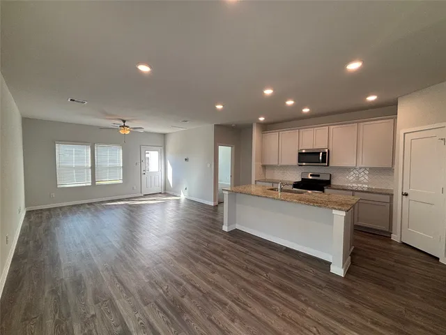 a kitchen with a refrigerator and white cabinets