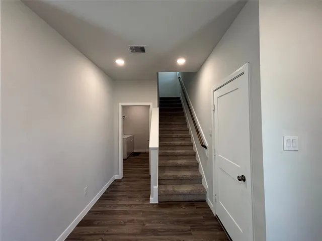 a view of a hallway with wooden floor and entryway