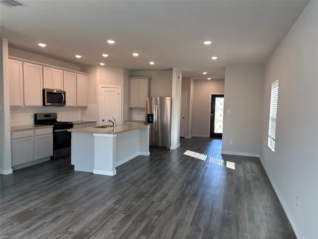 a view of kitchen with cabinets stainless steel appliances with wooden floor