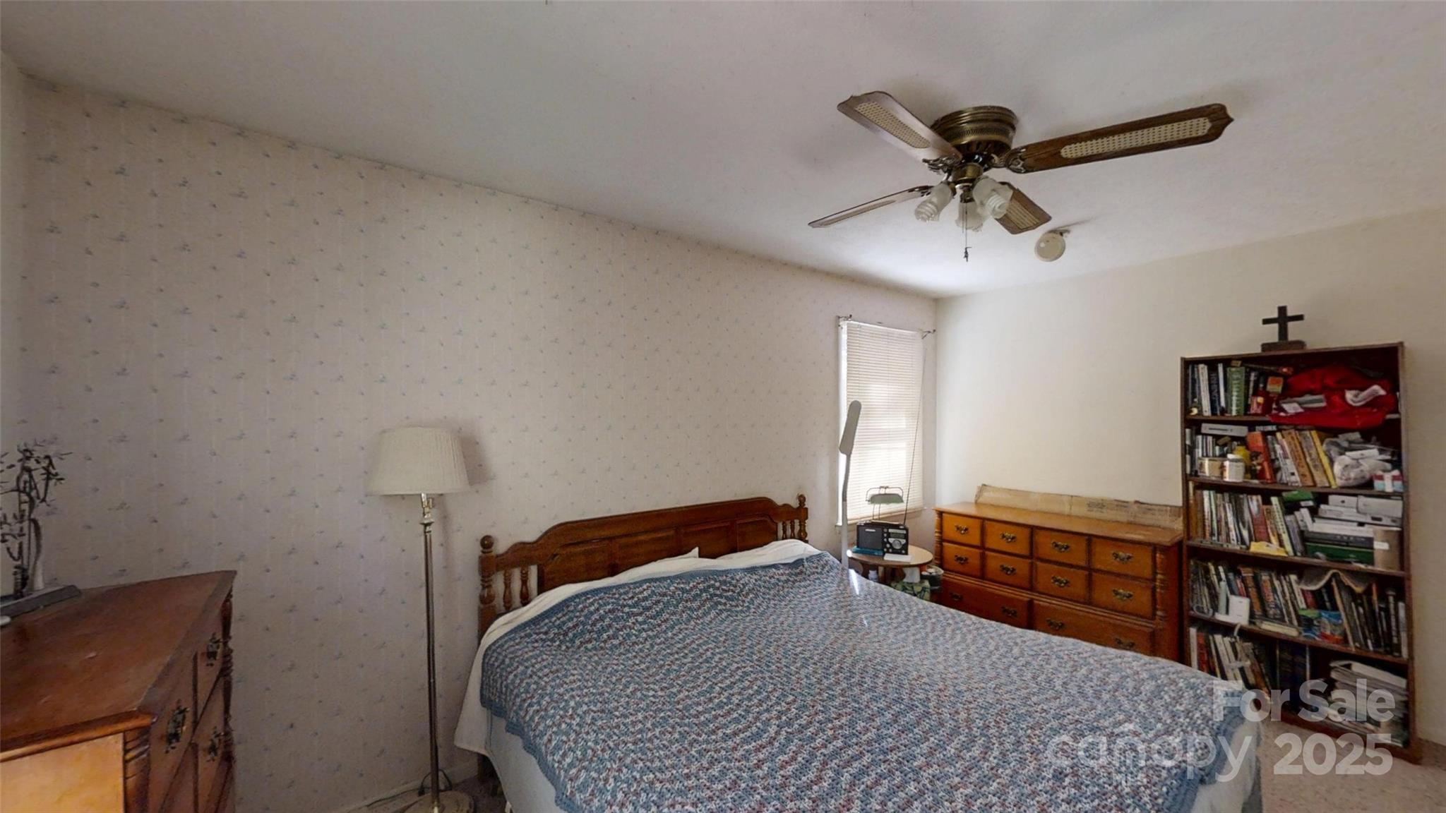 111 Cisco Road Asheville, NC 28805 - Photo 16 of 30 a bedroom with a bed a dresser and book shelfs