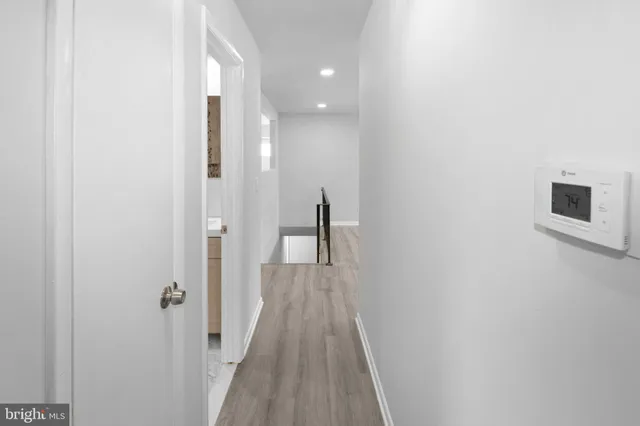 a view of a hallway with wooden floor and staircase