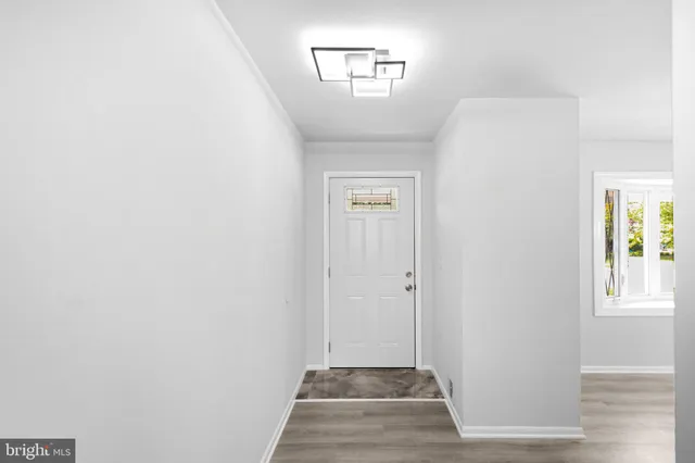 a view of a hallway with closet and a window