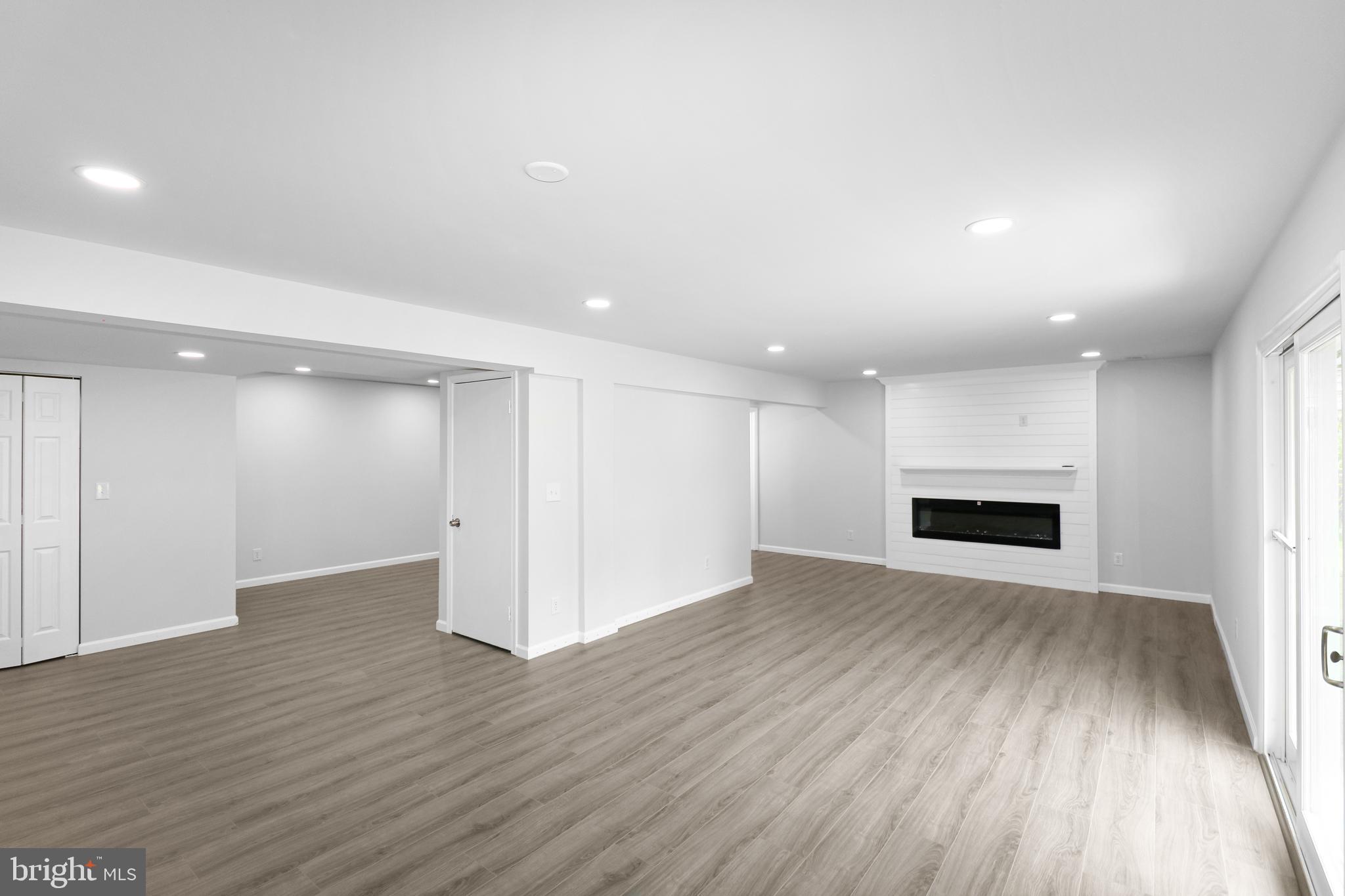 3311 Michele Lane Mitchellville, MD 20721 - Photo 29 of 44 an empty room with wooden floor fireplace and windows