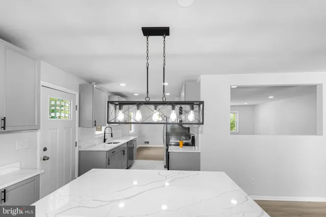 a kitchen with white cabinets and sink