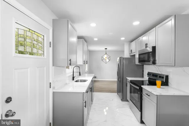 a kitchen with stainless steel appliances a refrigerator sink and microwave