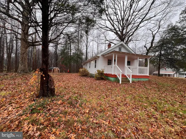 a view of a house with backyard and trees