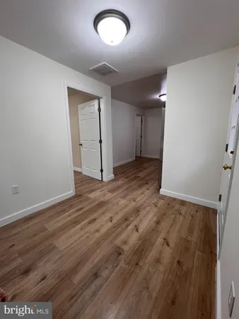 an empty room with wooden floor and closet