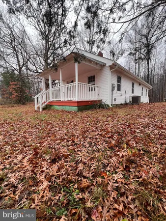 a backyard of a house with large trees and barbeque oven