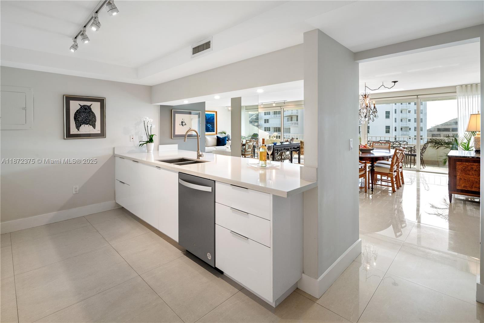 199 Ocean Ln Drive, Unit 1005 Key Biscayne, FL 33149 - Photo 14 of 35 a kitchen with a sink and white cabinets with wooden floor