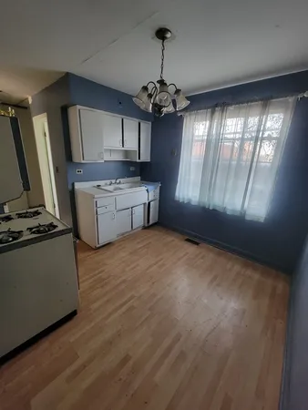 a kitchen with kitchen island granite countertop a stove top oven a sink and cabinets