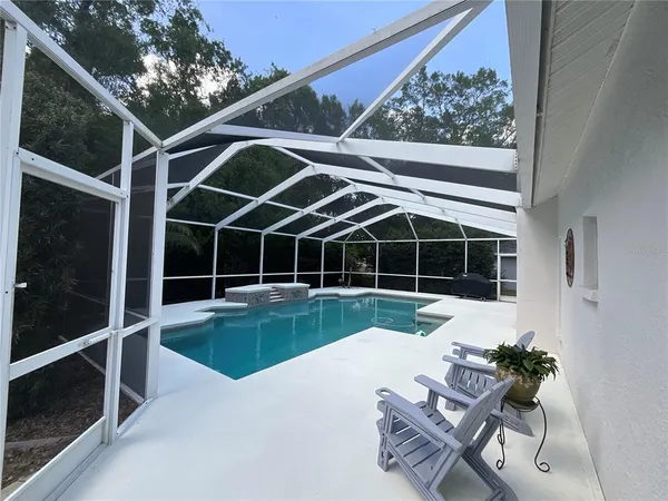 a view of a chairs and table in the patio with a lake view