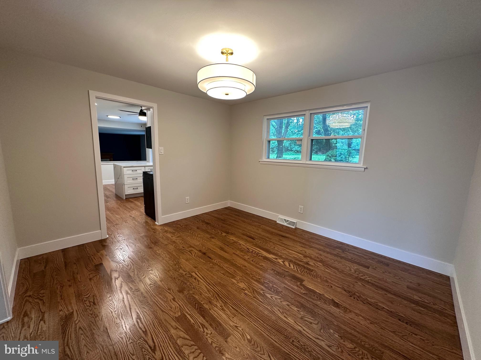 215 Bridge Road Upper Chichester, PA 19061 - Photo 17 of 35 an empty room with wooden floor cabinet and windows