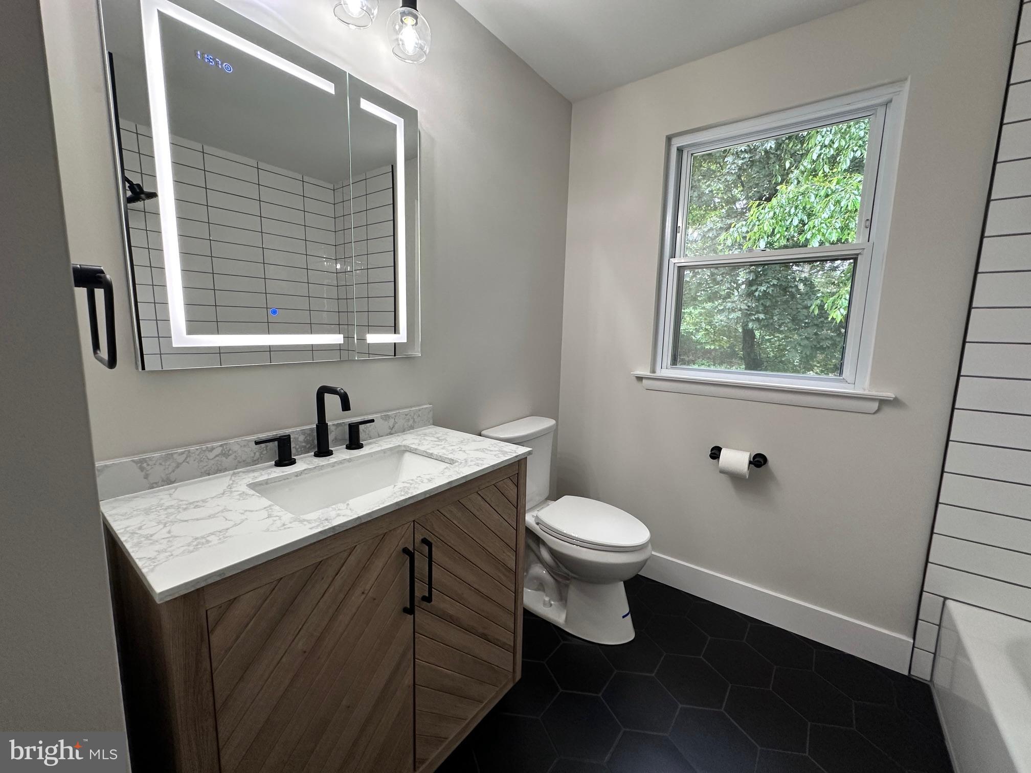 215 Bridge Road Upper Chichester, PA 19061 - Photo 19 of 35 a bathroom with a granite countertop sink toilet a mirror and window