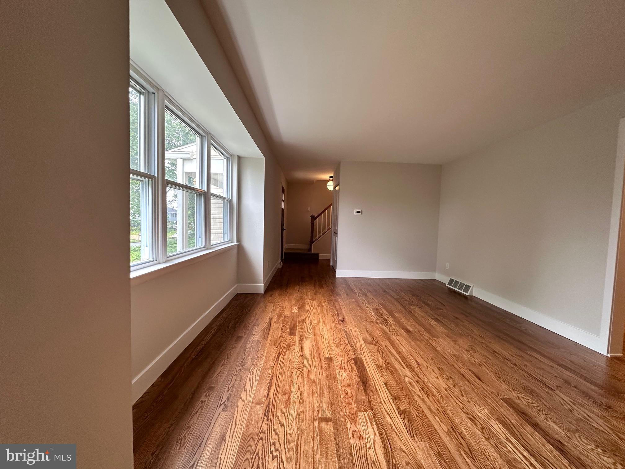215 Bridge Road Upper Chichester, PA 19061 - Photo 6 of 35 wooden floor in an empty room with a window