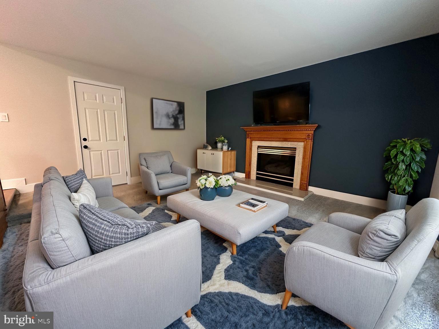 215 Bridge Road Upper Chichester, PA 19061 - Photo 8 of 35 a living room with furniture a flat screen tv and a fireplace