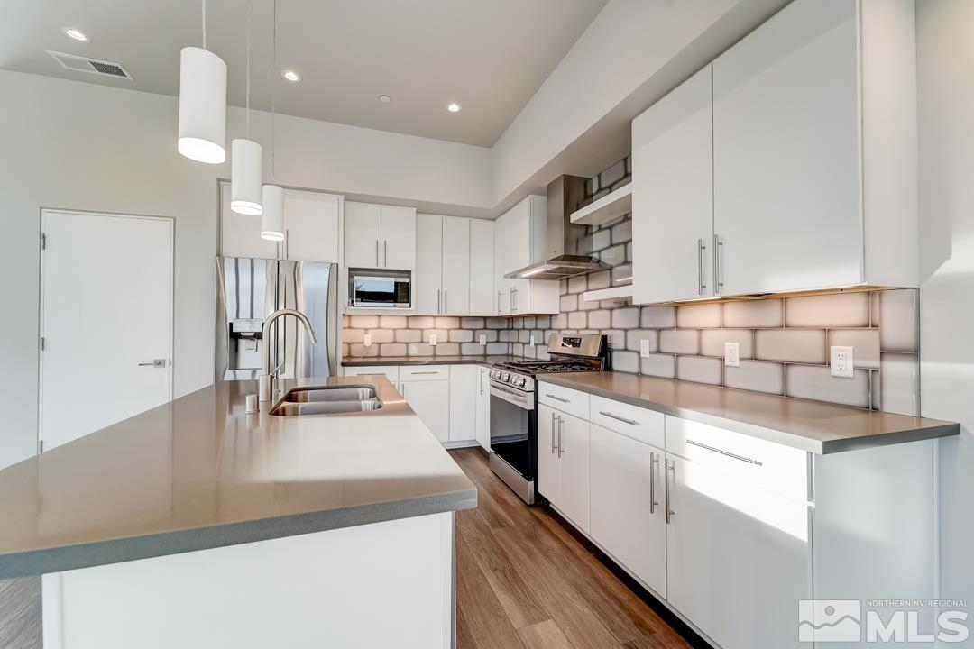 100 High Street, Unit 100 Reno, NV 89502 - Photo 2 of 20 a kitchen with kitchen island a sink stainless steel appliances and cabinets