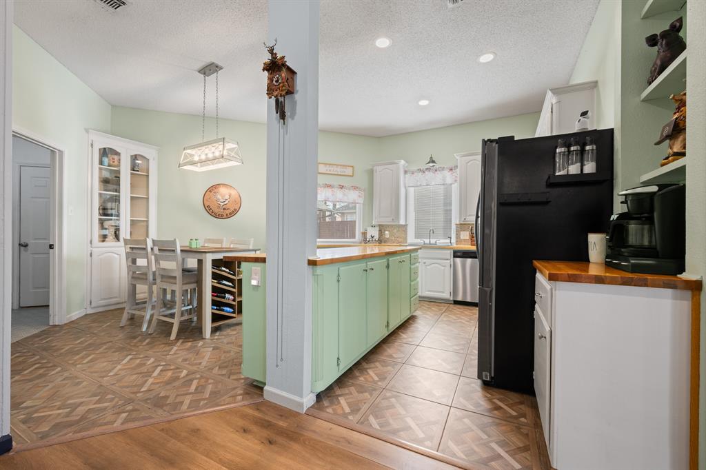 905 Evandale Road Burleson, TX 76028 - Photo 11 of 40 a kitchen with stainless steel appliances kitchen island granite countertop a refrigerator and microwave