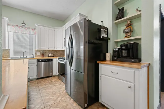 a kitchen with a refrigerator sink and cabinets