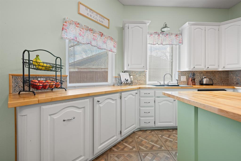 905 Evandale Road Burleson, TX 76028 - Photo 14 of 40 a kitchen with granite countertop white cabinets and window