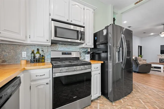 a kitchen with stainless steel appliances a stove a refrigerator and a microwave