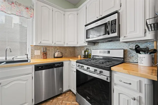 a kitchen with stainless steel appliances granite countertop a sink stove and microwave