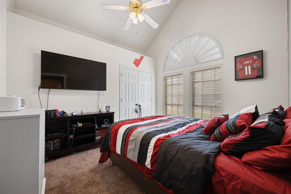 905 Evandale Road Burleson, TX 76028 - Photo 22 of 40 a bedroom with a bed and a flat screen tv