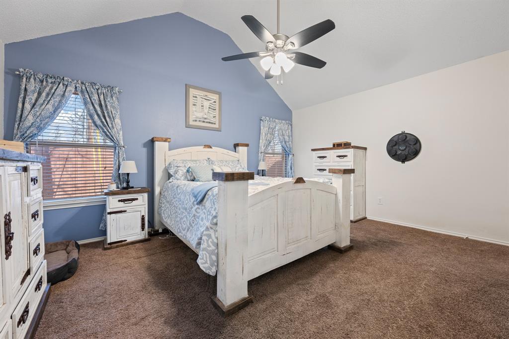 905 Evandale Road Burleson, TX 76028 - Photo 28 of 40 a bed room with a bed and a chandelier