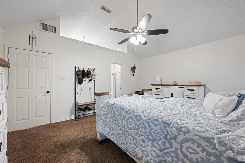 905 Evandale Road Burleson, TX 76028 - Photo 29 of 40 a bedroom with a bed and a chandelier