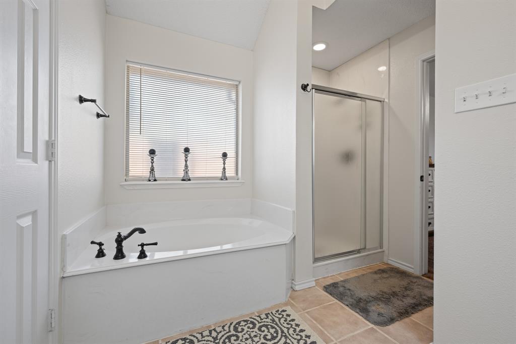 905 Evandale Road Burleson, TX 76028 - Photo 32 of 40 a bathroom with a bathtub and a shower