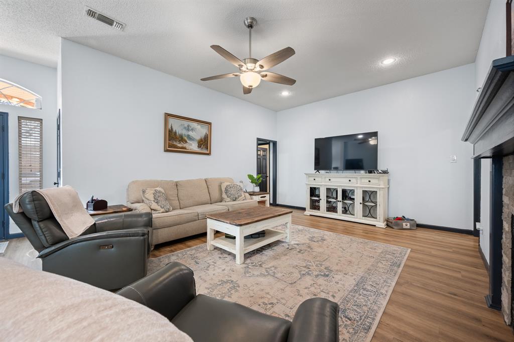 905 Evandale Road Burleson, TX 76028 - Photo 8 of 40 a living room with furniture a flat screen tv and a fireplace