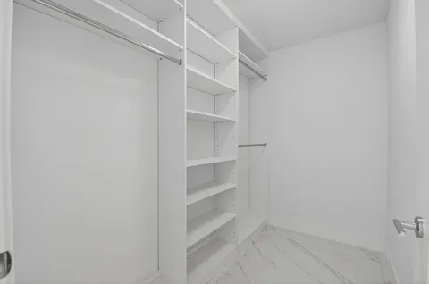 an empty room with sliding glass door and garden view