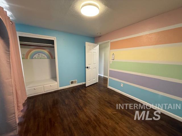 1139 Webster Street Clarkston, WA 99403 - Photo 19 of 34 Unfurnished bedroom with dark wood-style flooring, a closet, and a textured ceiling