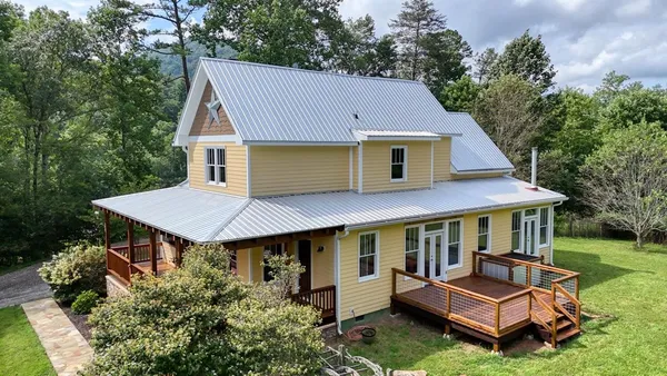 a aerial view of a house with a yard table and chairs