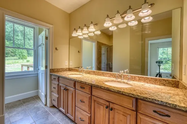 a bathroom with a granite countertop sink and a large mirror