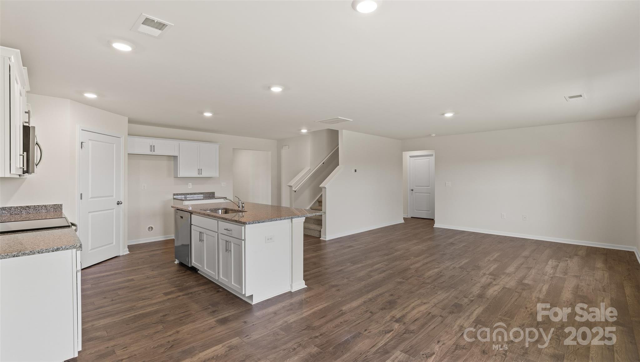 155 Callie River Clyde, NC 28721 - Photo 11 of 29 a kitchen with cabinets wooden floor and stainless steel appliances