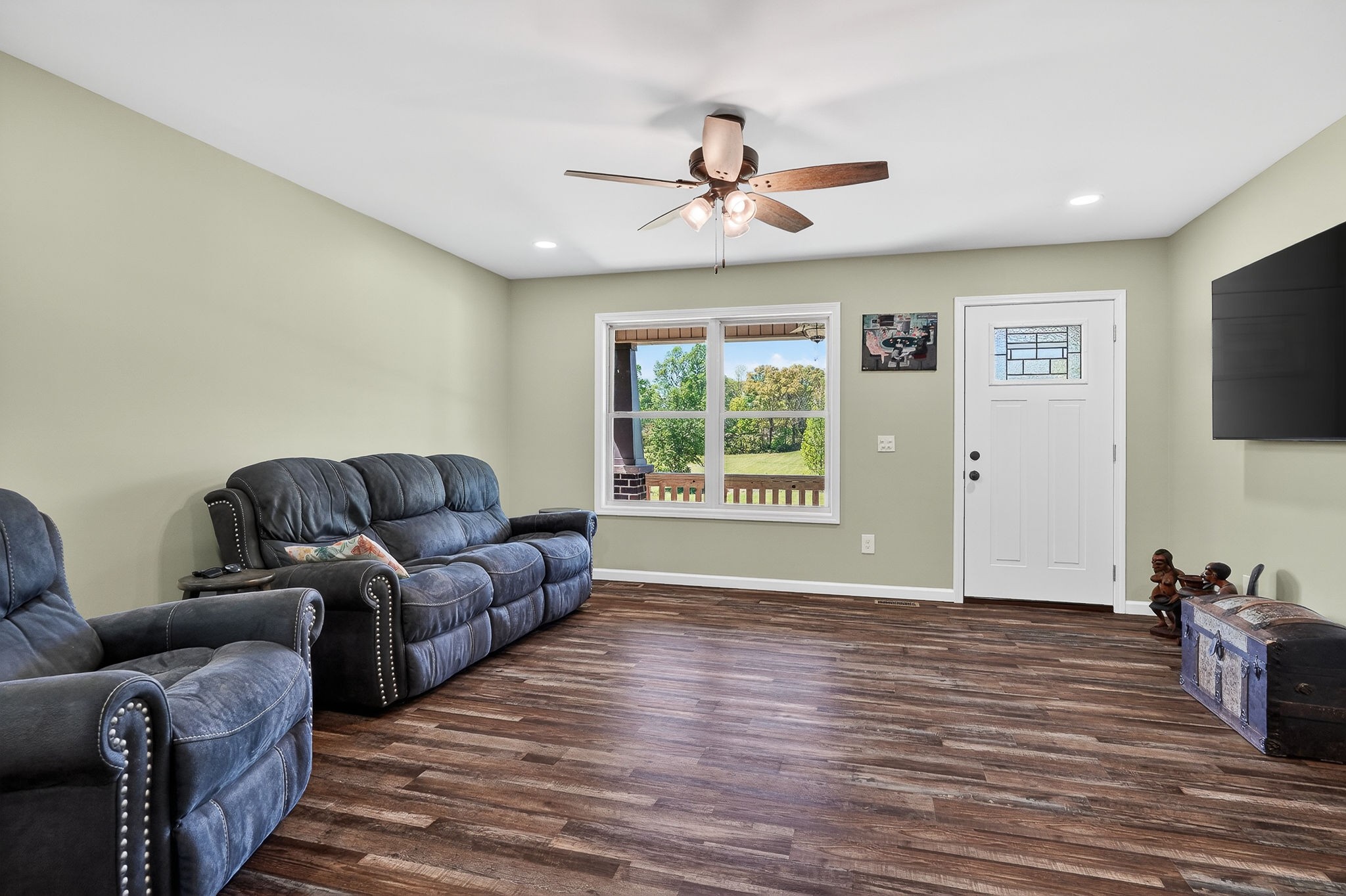 2110 Windle Community Road Cookeville, TN 38506 - Photo 13 of 35 a living room with couches a coffee table and a flat screen tv with wooden floor