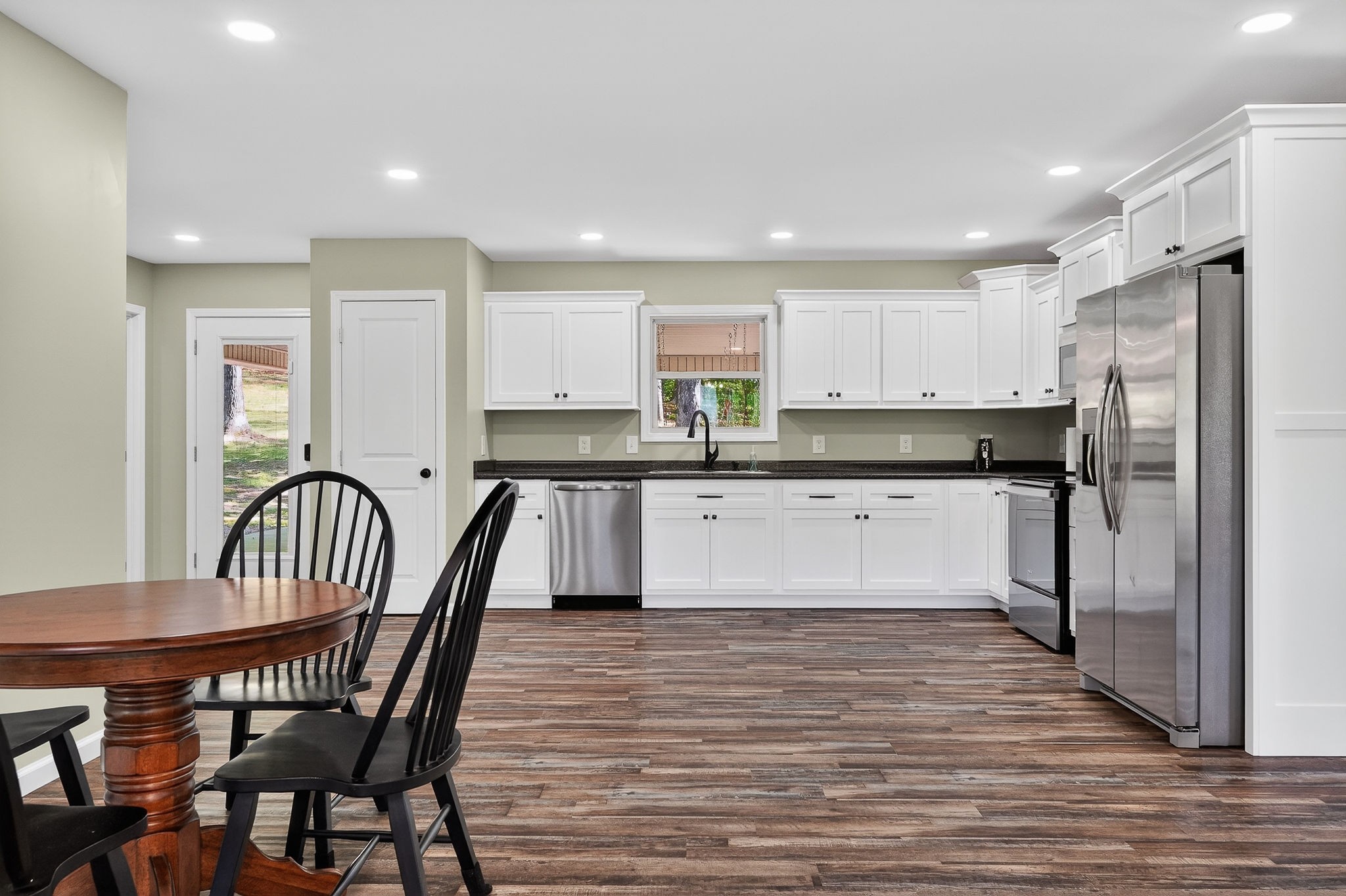 2110 Windle Community Road Cookeville, TN 38506 - Photo 14 of 35 a large kitchen with stainless steel appliances granite countertop a stove a sink a microwave a dining table and chairs