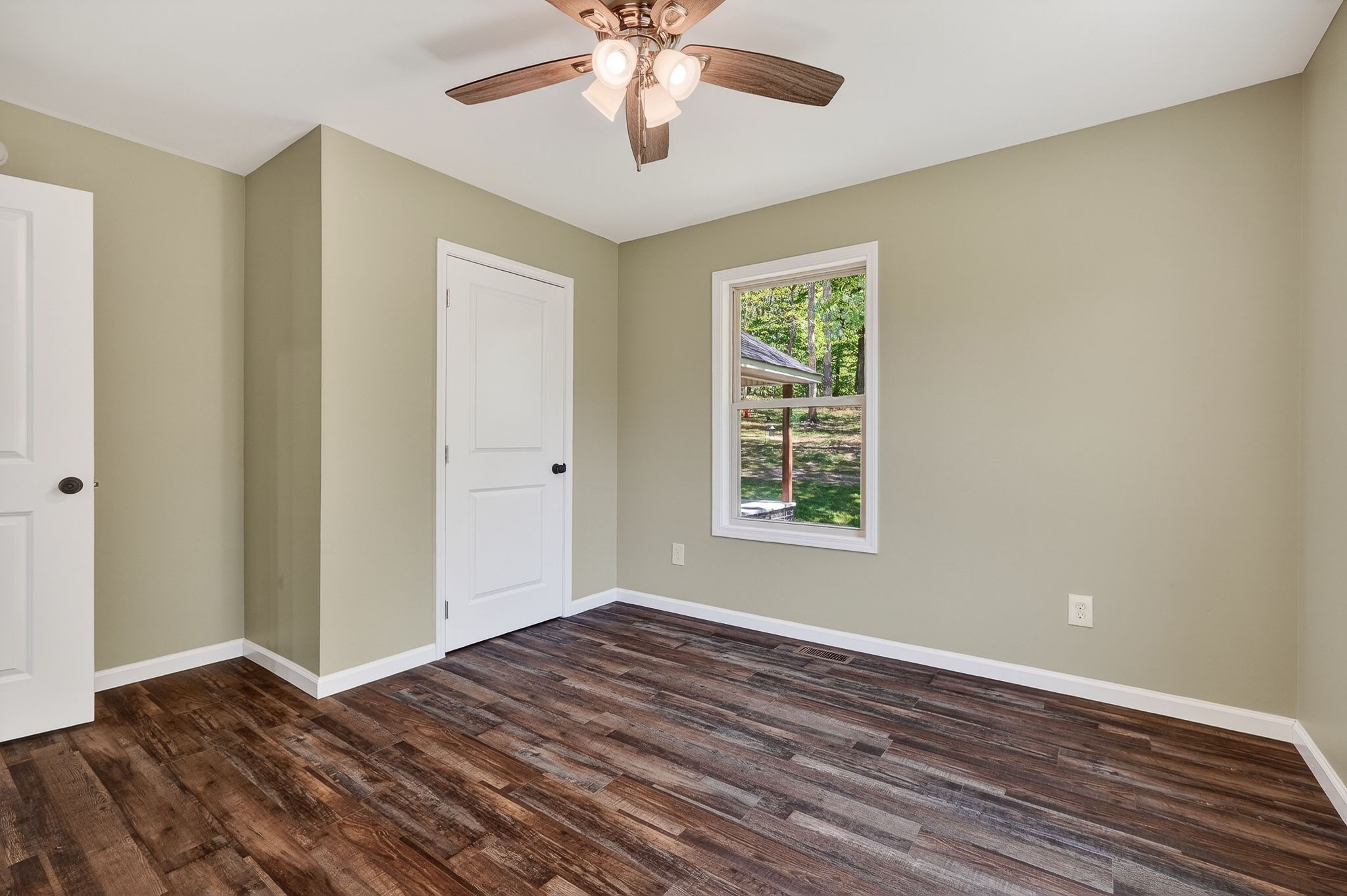 2110 Windle Community Road Cookeville, TN 38506 - Photo 26 of 35 an empty room with wooden floor chandelier fan and windows