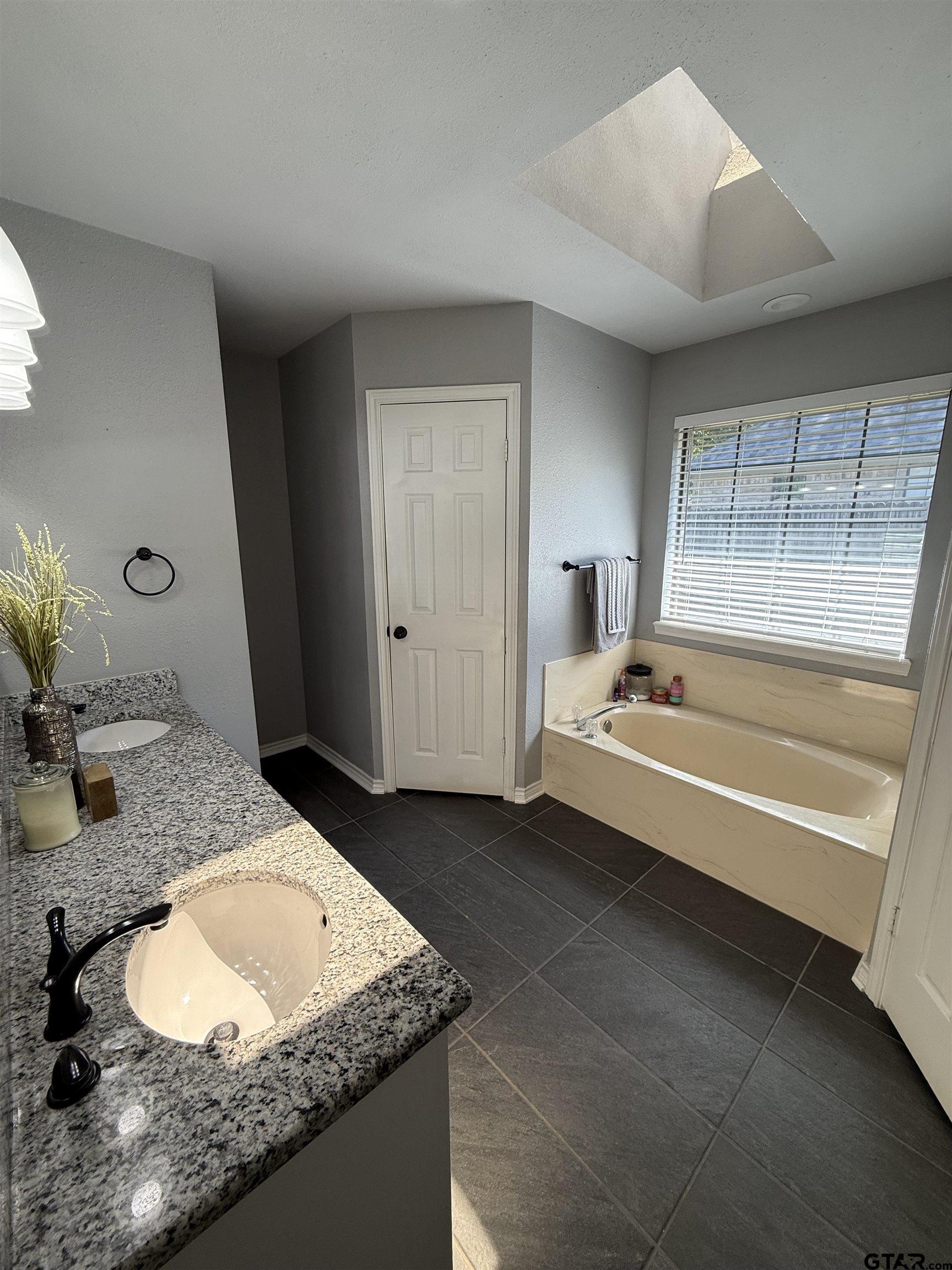 3207 McDonald Road Tyler, TX 75701 - Photo 13 of 24 a bathroom with a granite countertop sink and a bathtub