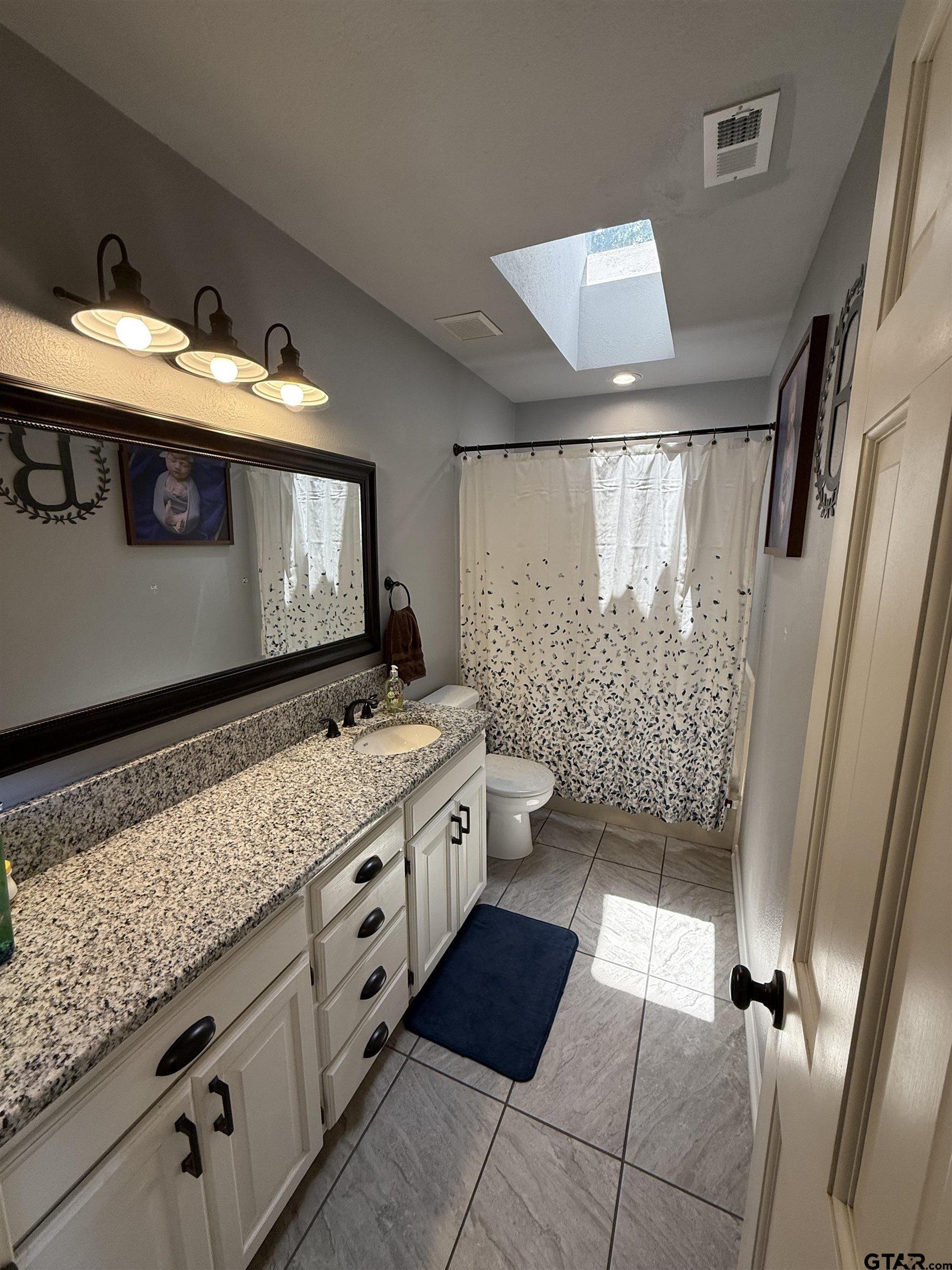 3207 McDonald Road Tyler, TX 75701 - Photo 17 of 24 a bathroom with a double vanity sink and a mirror