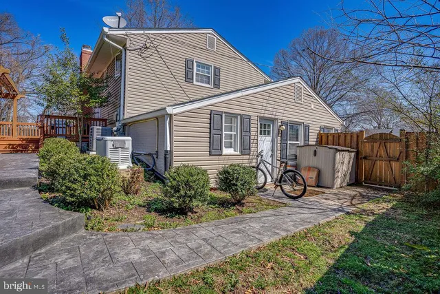 a view of a house with wooden fence next to a yard