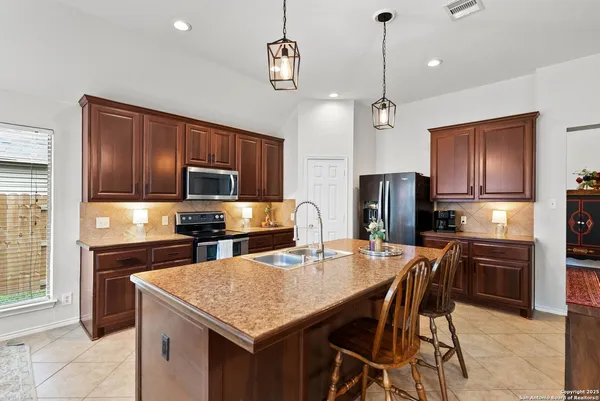 a kitchen with stainless steel appliances granite countertop a kitchen island hardwood floor sink stove dining table and chairs