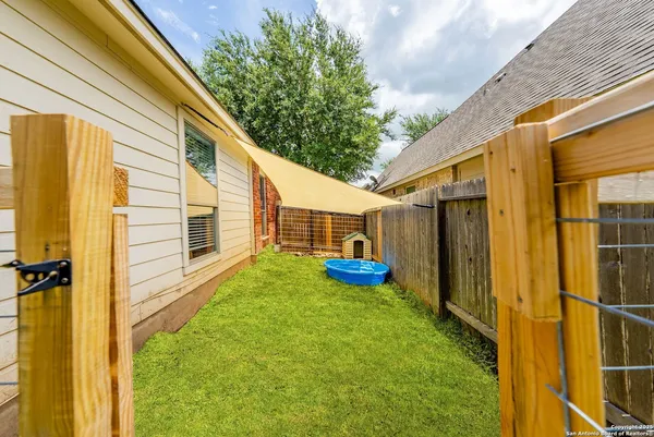 a view of a backyard with table and chairs and wooden fence